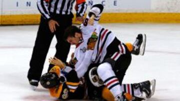 Andrew Shaw de  los Chicago Blackhawks golpea a  Brad Marchand, de los Bruins, durante el tercer partido de la final.
