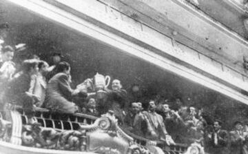 Santiago Bernabeu en el palco mostrando un trofeo