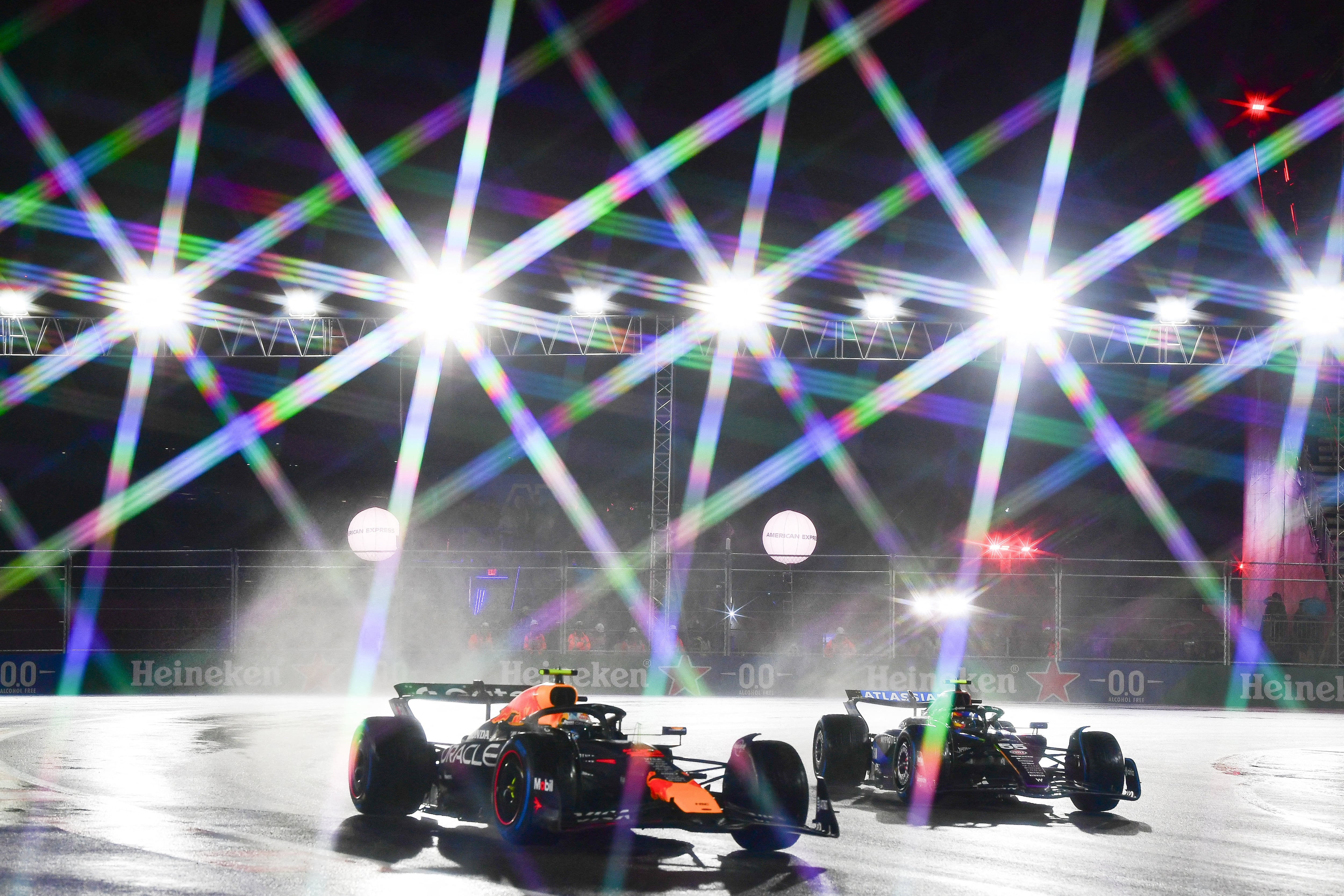 Nov 21, 2025; Las Vegas, NV, USA; (Editors Note: A star filter was used in the creation of this image.) Red Bull Racing driver Yuki Tsunoda (22) drives alongside Williams driver Carlos Sainz (55) during qualifying for the Las Vegas Grand Prix at Las Vegas Strip Circuit. Mandatory Credit: Gary A. Vasquez-Imagn Images