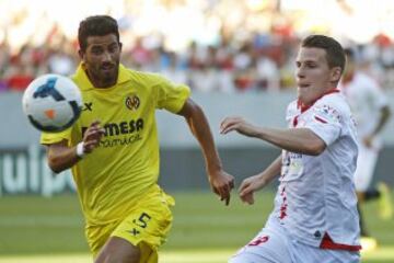 El delantero francés del Sevilla FC, Kevin Gameiro (d) y el defensa argentino del Villarreal Mateo Musacchio, durante el partido correspondiente a la trigésimo sexta jornada de Liga.