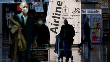 FILE PHOTO: Travellers walk with their luggage at Fiumicino Airport after Italy lifted quarantine restrictions for people arriving from the EU, Schengen zone countries, Britain and Israel in a bid to revive the tourism industry, as coronavirus disease (COVID-19) restrictions continue to ease, near Rome, Italy, May 17, 2021. REUTERS/Remo Casilli/File Photo