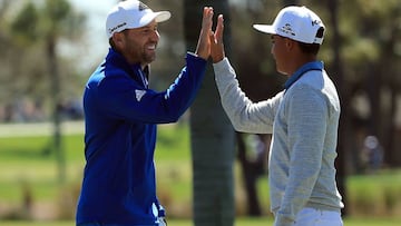 Sergio Garcia of Spain is congratulated by Rickie Fowler of the United States after holing out for eagle on the second hole.