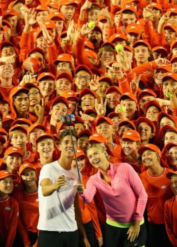 Maria Sharapova y el australiano Thanasi Kokkinakis posan junto a un grupo de asistentes de cancha en el Rod Laver Arena de Melbourne.