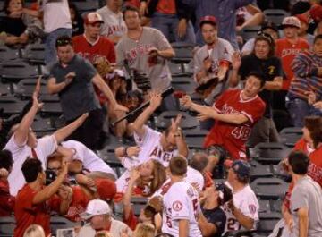 Reacción de los seguidores de un partido de béisbol en Los Angeles ante un bate que se le escapa a un jugador durante el partido.