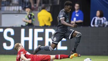 Vancouver Whitecaps' Alphonso Davies avoids a sliding tackle by Chicago Fire's Dax McCarty and assists on a goal by Kei Kamara during the second half of a Major League Soccer match Saturday, July 7, 2018, in Vancouver, British Columbia. (Darryl Dyck/The Canadian Press via AP)