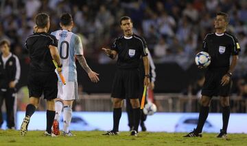 Argentina's forward Lionel Messi argues with second assistant referee Marcelo Vangasse next to Brazilian referee Sandro Ricci