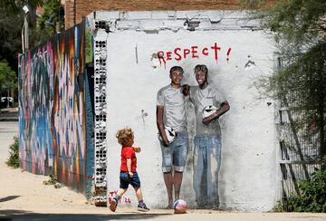 Un ni?o juega con su pelota delante de una pared de Barcelona en la que aparecen dibujados dos de los grandes ¨ªdolos de la selecci¨®n espa?ola que se ha plantado en la final de la Eurocopa de Alemania: Lamine Yamal y Nico Williams. Todo nuestro pa¨ªs est¨¢ ilusionado con que Espa?a consiga el domingo su cuarto trofeo continental.
