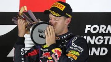 Vettel besa el trofeo de ganador.