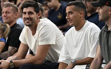 Toni Kroos, Thibaut Courtois y Lucas Vázquez observando detenidamente el duelo entre el Real Madrid de Baloncesto y los Dallas Mavericks.