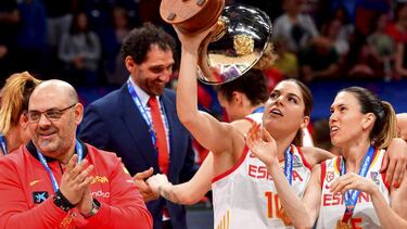 Lucas Mondelo aplaude, mientras Marta Xargay y Anna Cruz miran la copa de campeonas del Eurobasket 2019.