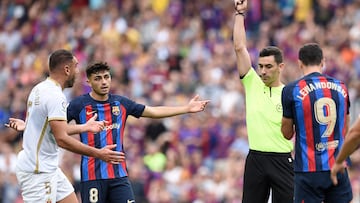 Spanish referee Muniz Ruiz presents a red card to Elche's Spanish defender Gonzalo Verdu (L) for fouling Barcelona's Polish forward Robert Lewandowski during the Spanish League football match between FC Barcelona and Elche CF at the Camp Nou stadium in Barcelona on September 17, 2022. (Photo by Josep LAGO / AFP)