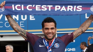 Paris Saint Germain's (PSG) new Brazilian defender Dani Alves poses with a scarf after a press conference on July 12, 2017, in Paris.