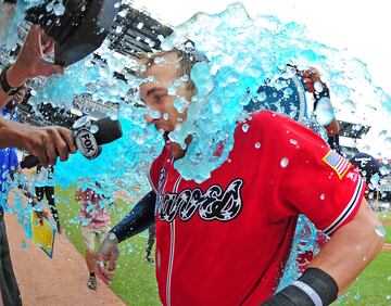 Micah Johnson moja a su compa?ero de los Atlanta Braves Lane Adams con una bebida isot¨®nica mientras realiza una entrevista.