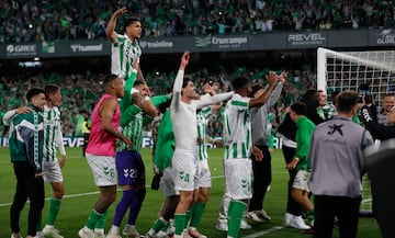 Los jugadores y aficionados del Betis, celebran la victoria ante el Sevilla tras finalizar el partido en el estadio Benito Villamarn.