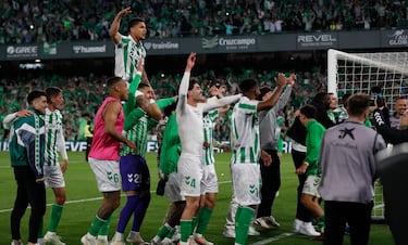 Los jugadores y aficionados del Betis, celebran la victoria ante el Sevilla tras finalizar el partido en el estadio Benito Villamarín.