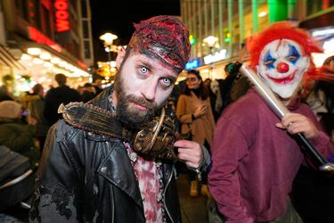 Personas disfrazadas con trajes terroríficos participan en una marcha de protesta zombi de Halloween en el centro de la ciudad de Essen, Alemania.