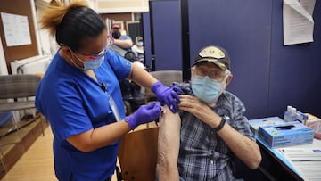 Lalain Reyeg administers a COVID-19 booster vaccine and an influenza vaccine to Army veteran William Craig at the Edward Hines Jr. VA Hospital on September 24, 2021, in Hines, Illinois. 