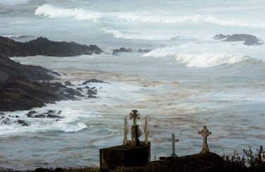 El petróleo derramado flota en la superficie del mar mientras las olas rompen en una playa cerca del pueblo de Camarinas, en el norte de España. 