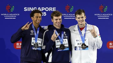 Swimming - World Aquatics Championships - Men 200m Medley Finals - World Aquatics Championships Arena, Singapore - July 31, 2025 Gold medallist France's Leon Marchand celebrates on the podium alongside silver medallist Shaine Casas of the U.S. and bronze medallist Hungary's Hubert Kos REUTERS/Hollie Adams