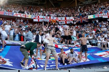 Aficionados ingleses celebran el pase de su selección sobre una de las lonas situadas en la grada del estadio.