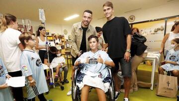 Iago Aspas y Denis Su&aacute;rez posan junto a un ni&ntilde;o con la camiseta del Celta en la visita al Hospital &Aacute;lvaro Cunqueiro durante la Navidad del a&ntilde;o 2019.