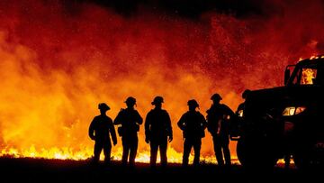 In this file photo taken on September 09, 2020 Butte County firefighters watch as flames quickly spread across a road at the Bear fire in Oroville, California. 