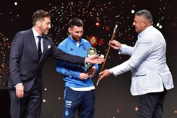 Lionel Messi (C) receives a ceremonial baton of leadership from the president of Conmebol, Paraguayan Alejandro Dominguez 