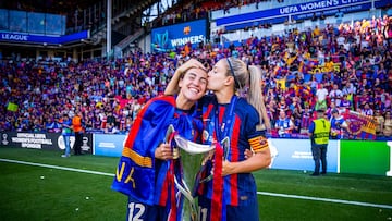 Alexia besa a Patri Guijarro mientras ambas sostienen la segunda Champions conquistada por el Barcelona.