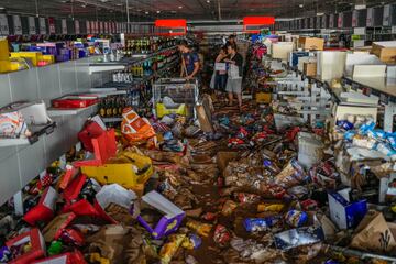 La gente recoge productos en un supermercado afectado por las inundaciones en Valencia, España.