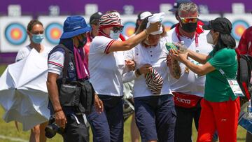 Svetlana Gomboeva (c) del equipo del Comit&eacute; Ol&iacute;mpico Ruso (ROC) recibe atenci&oacute;n al desmayarse por un golpe de calor hoy, durante la ronda de individual femenina de Tiro con arco por los Juegos Ol&iacute;mpicos 2020, en el campo de Yumenoshima en Tokio (Jap&oacute;n). 