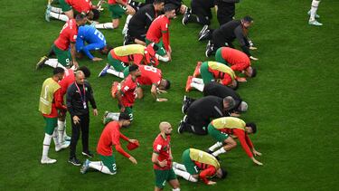 Los jugadores de la selección de Marruecos se arrodillan en señal de agradecimiento ante sus aficionados.