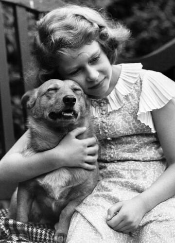 Isabel con diez años abraza a su perro. La Reina siempre ha tenido perros y siempre han sido descendientes de su primera mascota. 