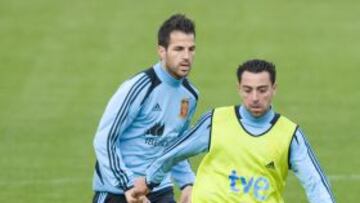 Xavi controla el balón ante la mirada de Cesc Fàbregas.
