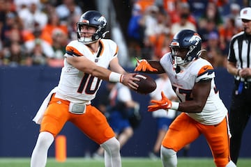 DENVER, COLORADO - AUGUST 18: Bo Nix #10 hands the ball off to Javonte Williams #33 of the Denver Broncos in the first half during the preseason game against the Green Bay Packers at Empower Field At Mile High on August 18, 2024 in Denver, Colorado.   Tyler Schank/Getty Images/AFP (Photo by Tyler Schank / GETTY IMAGES NORTH AMERICA / Getty Images via AFP)