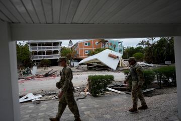 Miembros de la Guardia Nacional del Ejército de Florida caminan junto a una casa destruida que fue arrastrada por el huracán Helene, mientras verifican si quedan residentes antes de la llegada del huracán Milton.