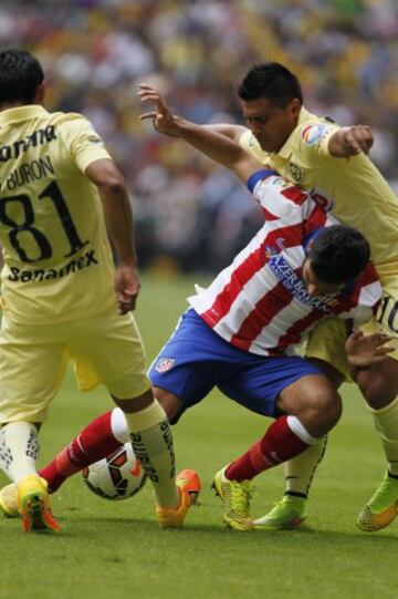 Arda Turan disputa el balón con Gil Burón  y con Osvaldo David Martínez.