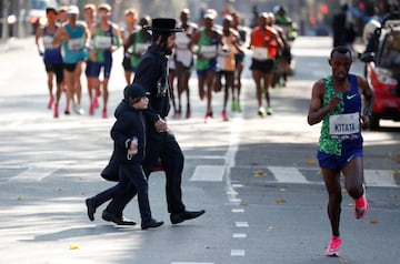 Un grupo de corredores encabezado por el etíope Shura Kitata Tola cruzan el barrio de Williamsburg.