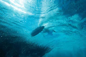 Vista de un surfista desde debajo de la ola. 
