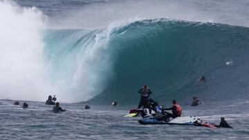 Ola gigante rompiendo ante la mirada de surfistas, filmers y un jet ski. 