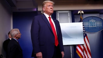 Dr. Anthony Fauci, Director of the National Institute of Allergy and Infectious Diseases, stands behind US President Donald Trump. 