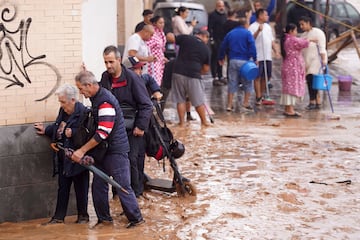 La gente camina por calles inundadas en Valencia.