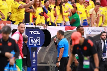 Referee Dario Herrera checks VAR for a possible penalty for Colombia during the CONMEBOL Copa America 2024 Group D match between Colombia and Paraguay.