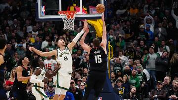 Nikola Jokic anota ante Kristaps Porzingis. en el Nuggets-Celtics jugado en Denver.