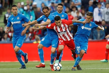 El centrocampista argentino del Atlético de Madrid Ángel Correa disputa el balón con los defensas del Getafe