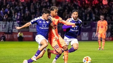 El delantero del FC Barcelona, Lamine Yamal (c), intenta llevarse el balón ante los defensores del CD Guadalajara durante el encuentro correspondiente a los dieciseisavos de final de la Copa del Rey que disputan hoy martes el CD Guadalajara y el FC Barcelona en el estadio Pedro Escartín, en Guadalajara.