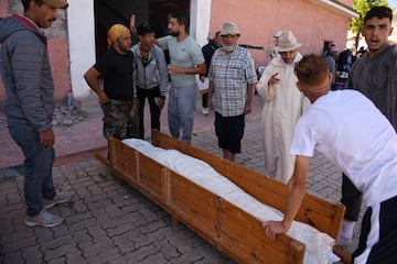 Vecinos y familiares se preparan para trasladar a un fallecido en el terremoto al cementerio, a 10 de septiembre de 2023, en Moulay Brahim, provincia de Al Haouz (Marruecos).