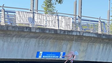 El muñeco y la pancarta colgadas sobre la SE-30 este jueves.