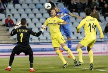 El defensa del Villarreal Aleksandar Pantic (c) y un jugador del Getafe luchan por el balón ante el portero del Villarreal Sergio Asenjo.