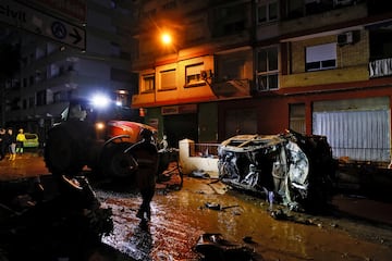 Un tractor retira un coche de la calle tras las lluvias torrenciales que provocaron inundaciones en Alfafar, Valencia.