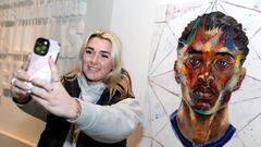 Una visitante al museo se hace un selfie con un retrato artístico de Jude Bellingham.